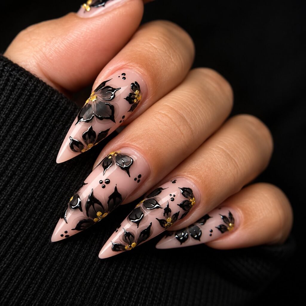 Manucure nude avec nail art floral noir et détails dorés réalisée à La Petite Coquetterie
